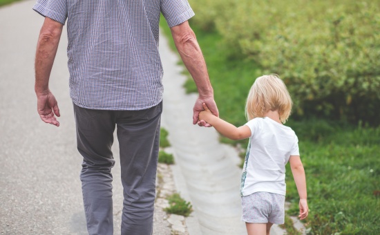 grandpa and child holding hands and walking